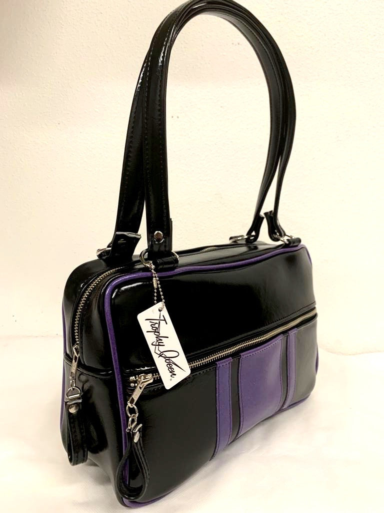 The Galaxy Tote Bag is slightly larger than the Galaxy Shoulder Bag in Grease Black and Beatnik Purple Glitter Vinyl Stripes withPlush Leopard Lining. Made with nickel hardware and nickel feet, vinyl zipper pull, and 25” (61cm) straps. Inside you’ll find an open divided pocket, a zipper pocket with serial number inside and signature Trophy Queen Label. Ships from California with an extra set of replacement straps included.