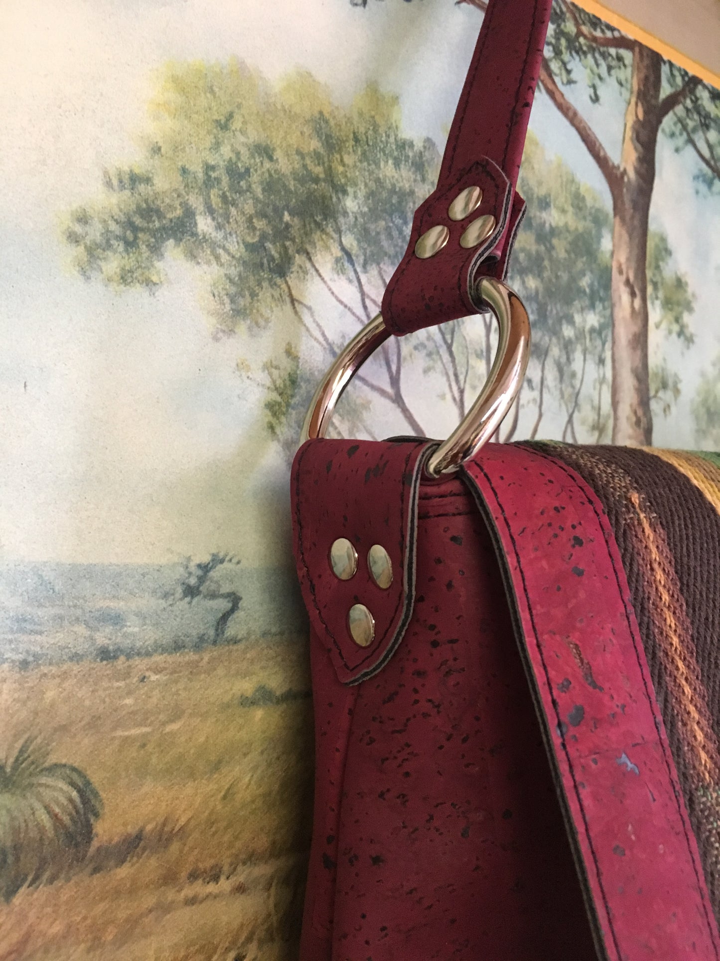 Fringe Saddle Bag in Genuine Sustainable Wine Colored Cork with Chocolate Serape Fabric with 24” (61cm) shoulder strap, magnetic closure, inside open divided pocket and zipper pocket with J.T. Christensen Designs Signature Label and hidden serial number. Ships from Sweden