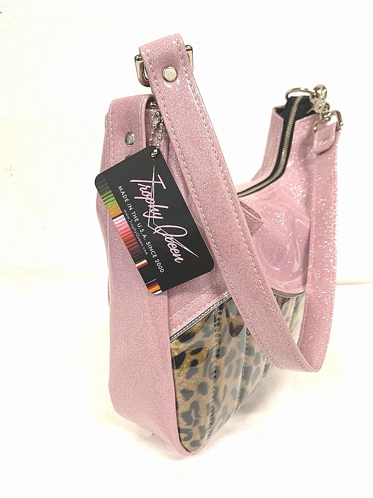 El Dorado Hobo Bag in Leopard and Blush Pink Glitter with plush leopard print lining handcrafted in California measuring approximately 12”x9”x2.5” (30.5cm x 23cm x 6cm) with inside open divided pocket and inside zipper pocket with inside hidden serial number and 26” should strap. Tote comes with vinyl zipper pull, nickel fee and signature Trophy Queen label. 