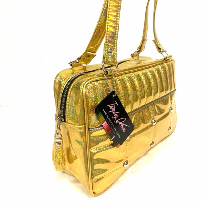 Lincoln Tote in Limited Edition Cosmic Gold Vinyl and Plush Leopard Lining. Made matching vinyl zipper pull, nickel feet, inside zipper pocket with serial number and open divided pocket with signature Trophy Queen label. The straps are approximately 25” and come with an extra set of replacement straps. Locally made and ships from California