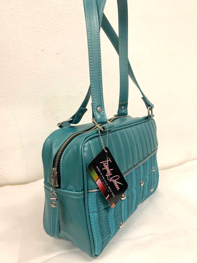 Lincoln Tote in Limited Edition Vintage Turquoise ‘65 Chevy Fabric and Vintage Turquoise Vinyl with Plush Leopard Lining. Made from NOS Vintage 1965 Chevy Upholstery Fabric with matching vinyl zipper pull, nickel feet, inside zipper pocket with serial number and open divided pocket with signature Trophy Queen label. The straps are approximately 25” and come with an extra set of replacement straps. Locally made and ships from California