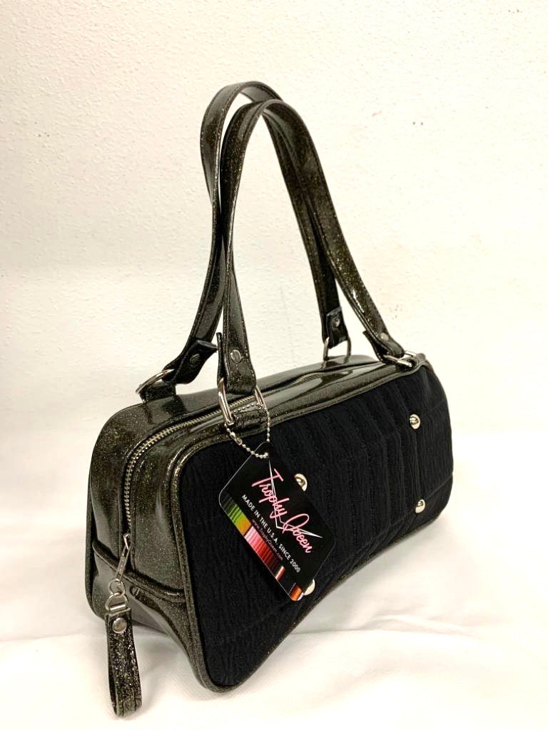 Limited Edition Galaxy Shoulder Bag with Black '71 Pontiac Fabric and Black Gold Glitter Vinyl with Plush Leopard Lining. Made from NOS vintage 1971 Pontiac Catalina Upholstery fabric and nickel hardware. Inside you’ll find an open divided pocket, a zipper pocket with serial number inside and signature Trophy Queen Label. Outside 25” straps (approx 63cm), vinyl zipper pull and protective nickel feet. Made and ships from California with an extra set of replacement straps.