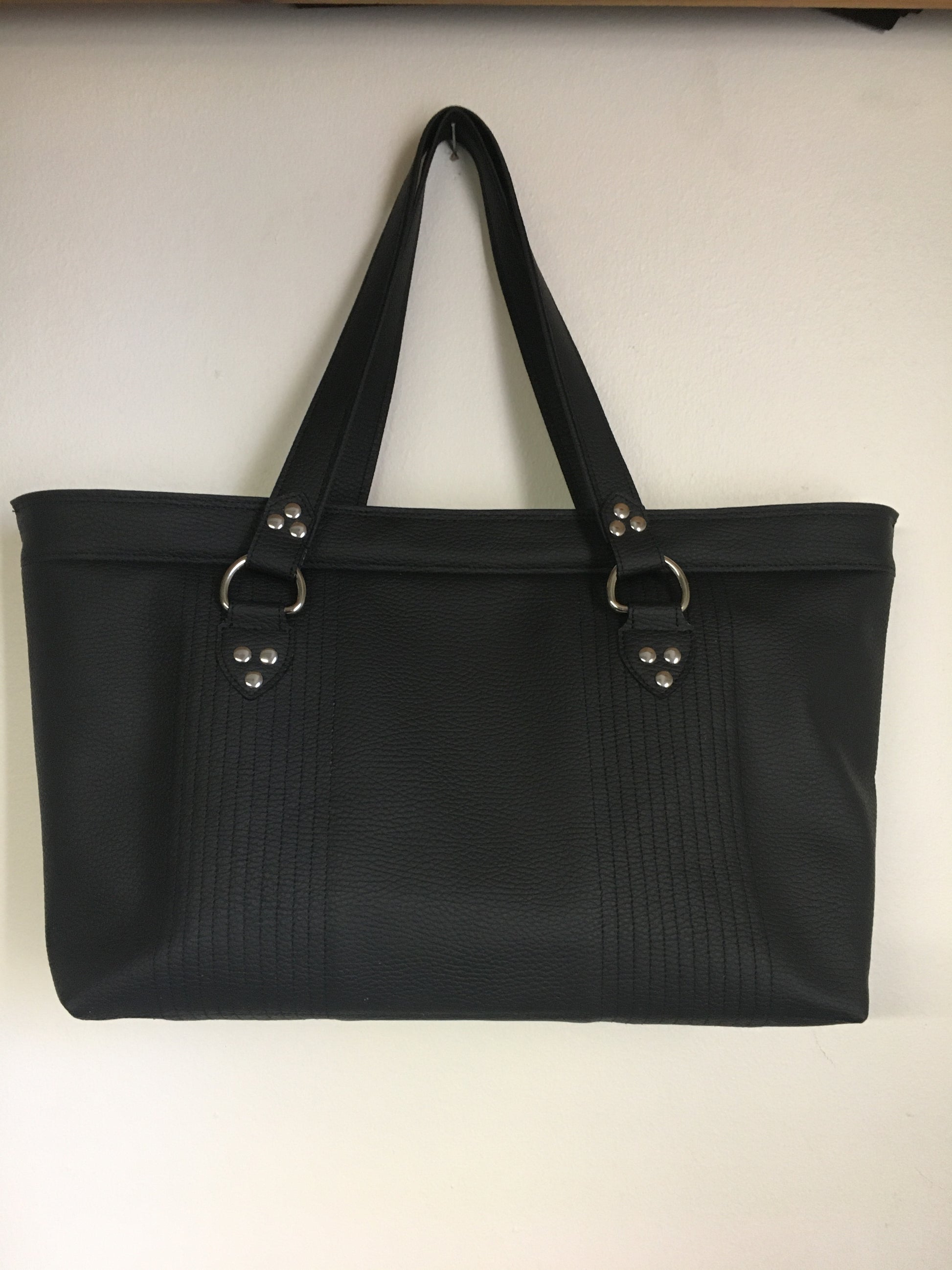Open Tote with Mercury Style Pleating in Limited Edition Pebble Black Vinyl Lined with Aztec Print Lining. Measuring 15” across bottom (19” across top) x 10” x 5” (38 cm At Bottom / 48.25 cm At Top x 25.5 cm Tall x 12.5 cm Wide) and 24” (61cm) Straps. An open divided pocket and zipper pocket with hidden serial number and signature J.T. Christensen Label.