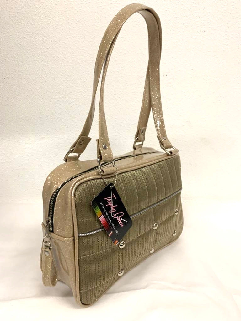 Lincoln Tote in Limited Edition Vintage Gold ‘64 Buick Fabric and Champagne Glitter Vinyl with Plush Leopard Lining. Made from NOS Vintage 1964 Buick Skylark Upholstery Fabric with matching vinyl zipper pull, nickel feet, inside zipper pocket with serial number and open divided pocket with signature Trophy Queen label. The straps are approximately 25” and come with an extra set of replacement straps. Locally made and ships from California