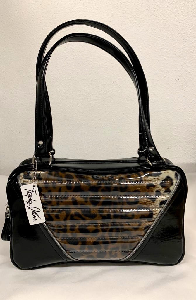Comet Tote in grease black vinyl and plush leopard with clear overlay with plush leopard lining handcrafted in California with nickel hardware, an extra set of straps, vinyl zipper pull, inside open divided pocket, zipper pocket with serial number inside and signature Trophy Queen label.