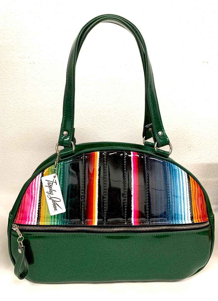 Lucky Strike Bowling Style Bag made with Dark Green Glitter and Mexican Blanket with Clear Overly Vinyl and lined with Plush Leopard inside with front zipper pocket, shoulder straps with extra set included inside has divided pocket, zipper pocket with hidden serial number inside and signature trophy queen label.