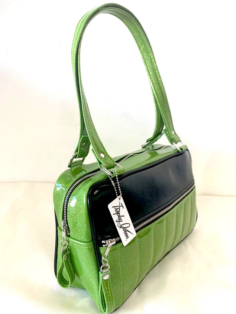 Fairlane Tote Bag in Lime Green Glitter Vinyl and Grease Black Vinyl with plush Leopard Lining. This purse has matching vinyl zipper pull, nickel feet, inside zipper pocket with serial number and open divided pocket with signature Trophy Queen label. The straps are approximately 25” and come with an extra set of replacement straps. Locally made and ships from California.