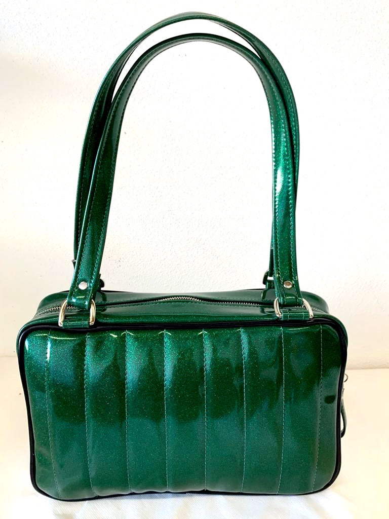 Fairlane Tote Bag in Green Glitter Vinyl and Grease Black Vinyl with plush Leopard Lining. This purse has matching vinyl zipper pull, nickel feet, inside zipper pocket with serial number and open divided pocket with signature Trophy Queen label. The straps are approximately 25” and come with an extra set of replacement straps. Locally made and ships from California.