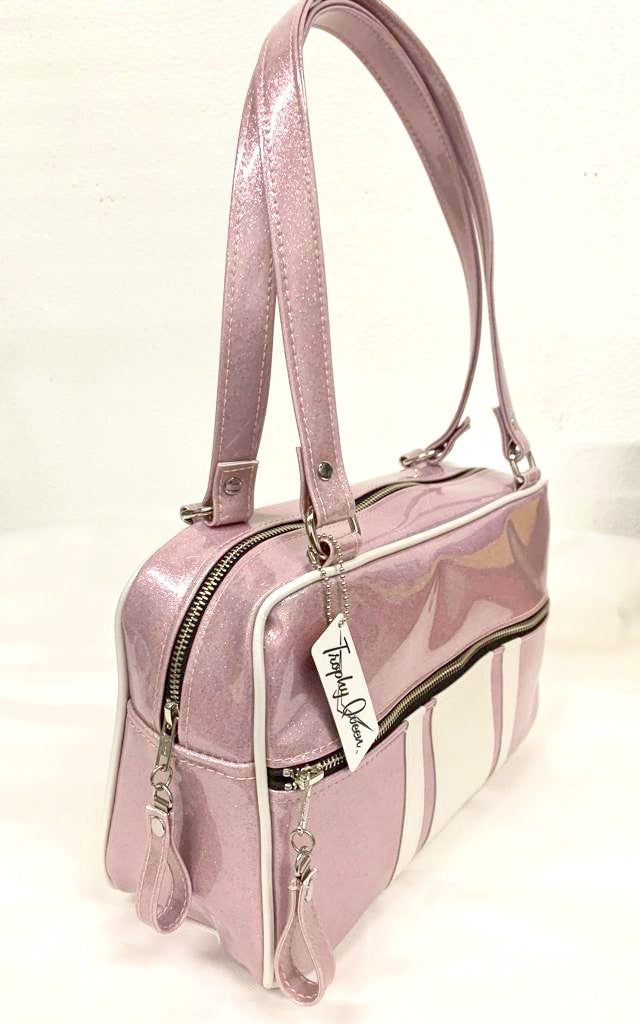 GTO Tote Bag in Blush Pink Glitter and Pearl White Vinyl with Plush Leopard Lining has matching vinyl zipper pull, nickel feet, inside zipper pocket with serial number and open divided pocket with signature Trophy Queen label. The straps are approximately 25” and come with an extra set of replacement straps. Locally made and ships from California.