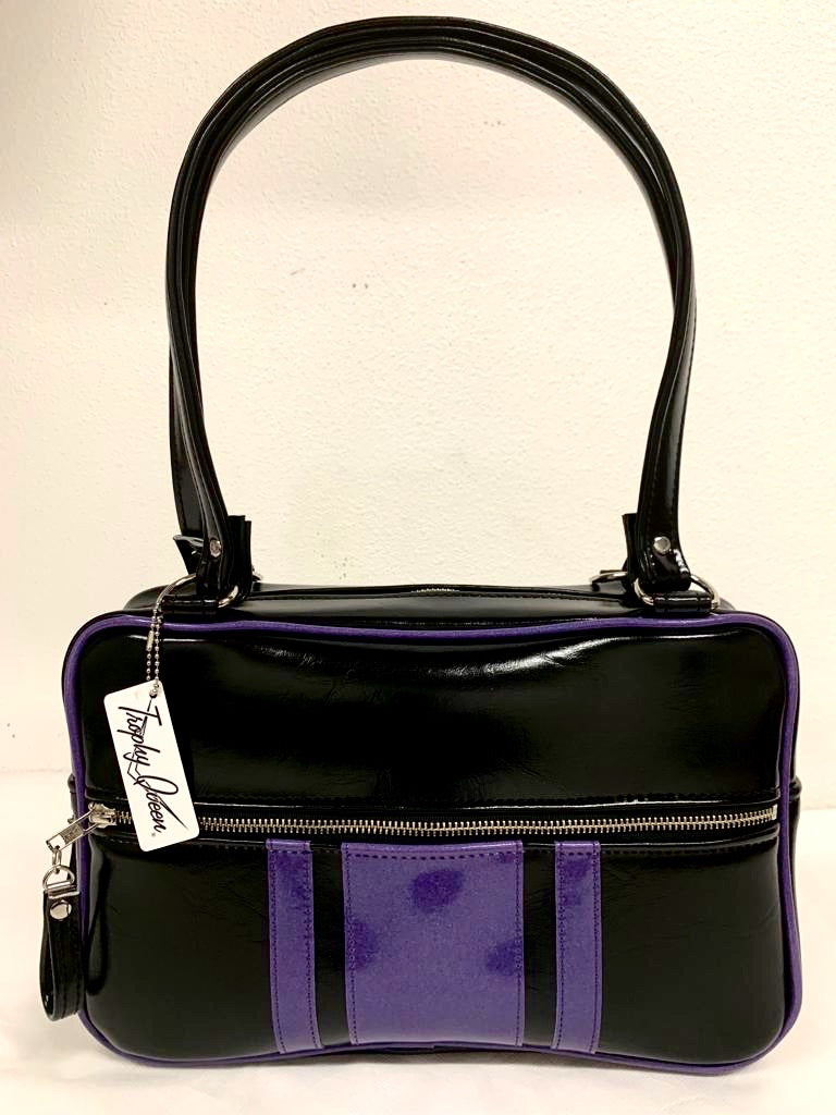 The Galaxy Tote Bag is slightly larger than the Galaxy Shoulder Bag in Grease Black and Beatnik Purple Glitter Vinyl Stripes withPlush Leopard Lining. Made with nickel hardware and nickel feet, vinyl zipper pull, and 25” (61cm) straps. Inside you’ll find an open divided pocket, a zipper pocket with serial number inside and signature Trophy Queen Label. Ships from California with an extra set of replacement straps included.