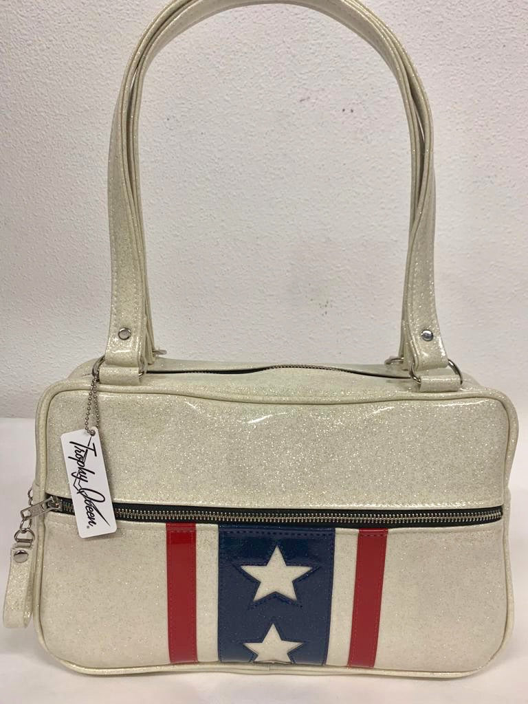 Evel Knievel Tote Bag lined with plush leopard is handcrafted in California with nickel hardware and 25” straps plus it comes with replacement straps. Inside open divided pocket and inside zipper pocket with serial number hidden inside. Nickel feet, vinyl zipper pull, and signature Trophy Queen Label included. The perfect size bag for any trip!