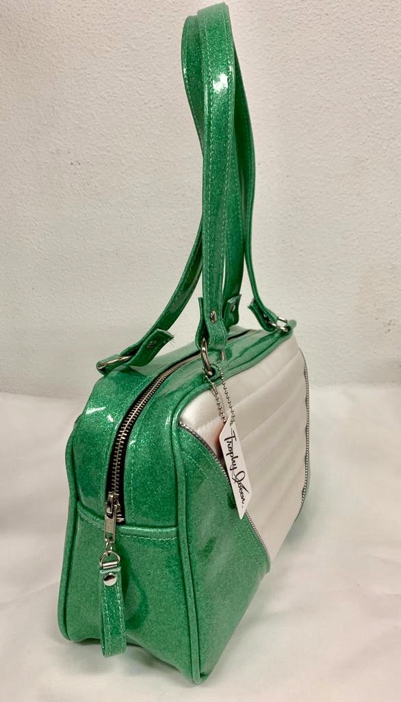 Comet Tote in sea foam green glitter vinyl and pearl white vinyl with plush leopard lining handcrafted in California with nickel hardware, an extra set of straps, vinyl zipper pull, inside open divided pocket, zipper pocket with serial number inside and signature Trophy Queen label.