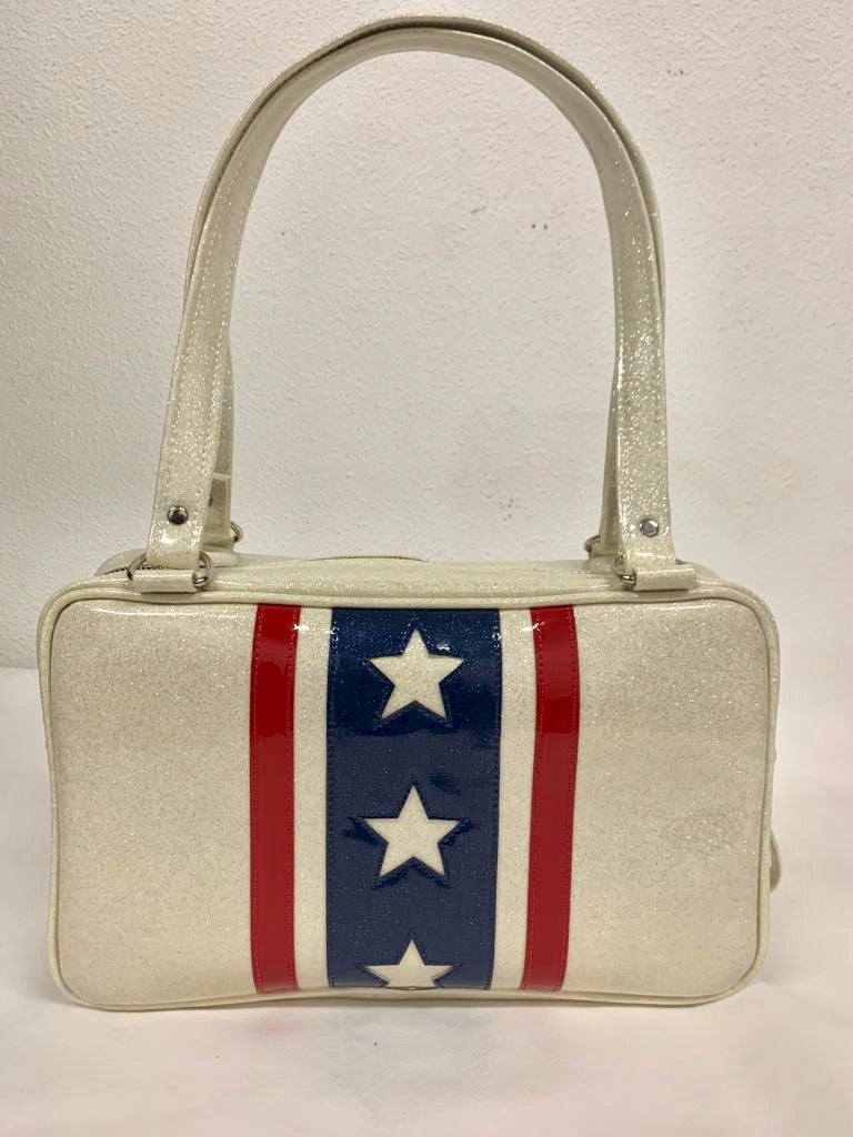 Evel Knievel Tote Bag lined with plush leopard is handcrafted in California with nickel hardware and 25” straps plus it comes with replacement straps. Inside open divided pocket and inside zipper pocket with serial number hidden inside. Nickel feet, vinyl zipper pull, and signature Trophy Queen Label included. The perfect size bag for any trip!