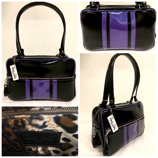 The Galaxy Tote Bag is slightly larger than the Galaxy Shoulder Bag in Grease Black and Beatnik Purple Glitter Vinyl Stripes withPlush Leopard Lining. Made with nickel hardware and nickel feet, vinyl zipper pull, and 25” (61cm) straps. Inside you’ll find an open divided pocket, a zipper pocket with serial number inside and signature Trophy Queen Label. Ships from California with an extra set of replacement straps included.