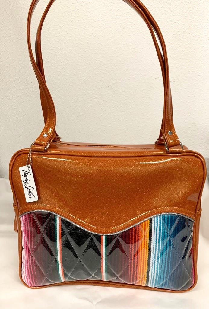 Diamond Pleat Tuck and Roll Business Bag comes in Tangerine Glitter Vinyl and Mexican Blanket with plush leopard lining, 29” straps with nickel hardware and comes with extra replacement straps! Inside has an open divided pocket and zipper pocket with hidden serial number. Tote comes with vinyl zipper pull, nickel fee and signature Trophy Queen label. Made with love in California.