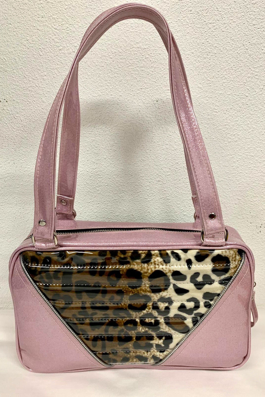 Comet Tote in blush pink glitter vinyl and plush leopard with clear overlay with plush leopard lining handcrafted in California with nickel hardware, an extra set of straps, vinyl zipper pull, inside open divided pocket, zipper pocket with serial number inside and signature Trophy Queen label.