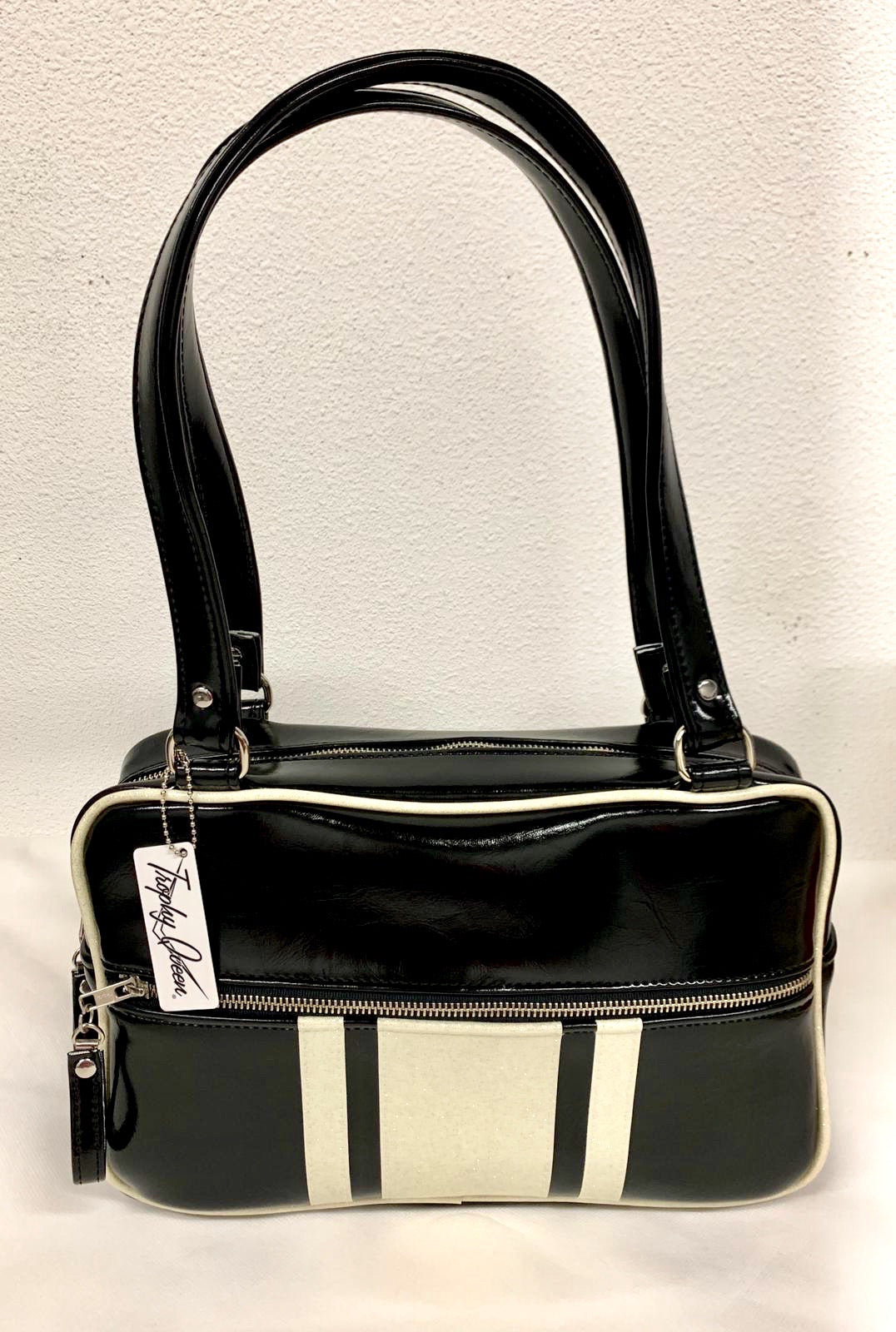 The Galaxy Tote Bag is slightly larger than the Galaxy Shoulder Bag in Grease Black Vinyl and White Glitter Stripes with Plush Leopard Lining. Made with nickel hardware and nickel feet, vinyl zipper pull, and 25” (61cm) straps. Inside you’ll find an open divided pocket, a zipper pocket with serial number inside and signature Trophy Queen Label. Ships from California with an extra set of replacement straps included.