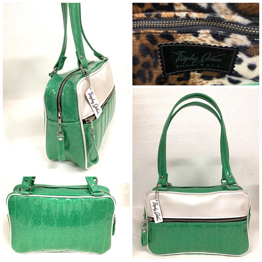 Fairlane Tote Bag in Seafoam Green Glitter and Pearl White Vinyl with plush Leopard Lining. This purse has matching vinyl zipper pull, nickel feet, inside zipper pocket with serial number and open divided pocket with signature Trophy Queen label. The straps are approximately 25” and come with an extra set of replacement straps. Locally made and ships from California.