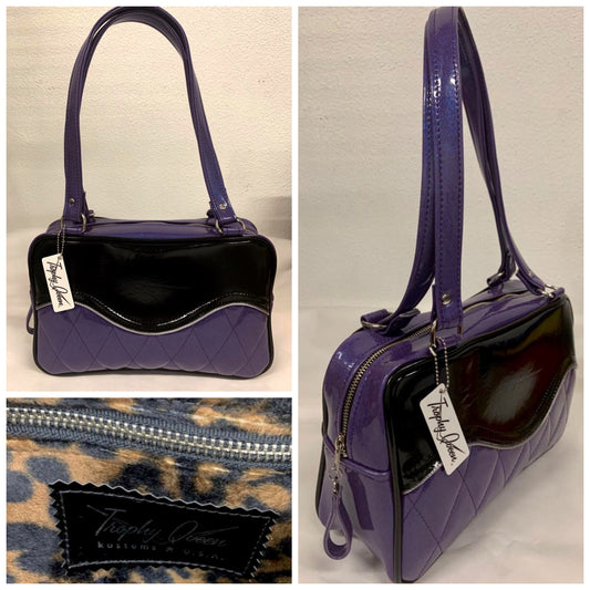 The Diamond Pleat Tuck and Roll Tote in Beatnik Purple Glitter Vinyl and Grease Black with plush leopard lining is handcrafted in California with nickel hardware and 25” straps plus it comes with replacement straps. Inside open divided pocket and inside zipper pocket with serial number hidden inside. Nickel feet, vinyl zipper pull, and signature Trophy Queen Label included. The perfect size bag for any trip!