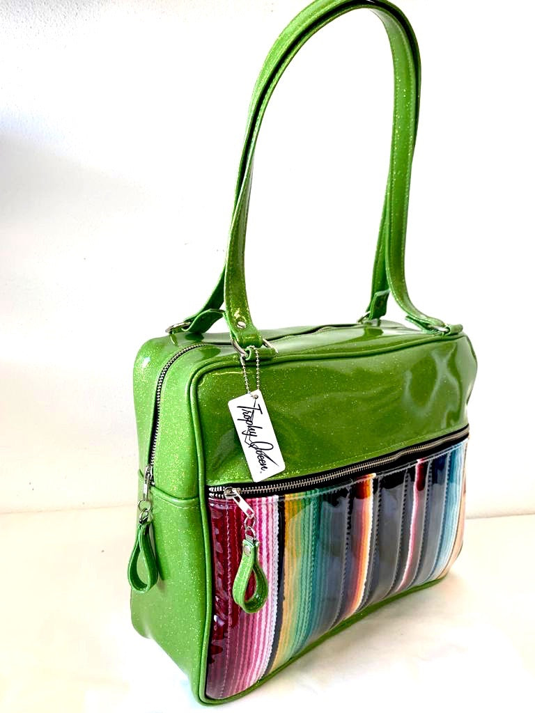 Fairlane Business Bag with Genuine Mexican Blanket with Clear Overlay and Lime Green Glitter Vinyl lined with plush Leopard fabric. The straps are 29” with nickel hardware and come with extra replacement straps! Inside has an open divided pocket and zipper pocket with hidden serial number. Tote comes with vinyl zipper pull, nickel fee and signature Trophy Queen label. Made with love in California.