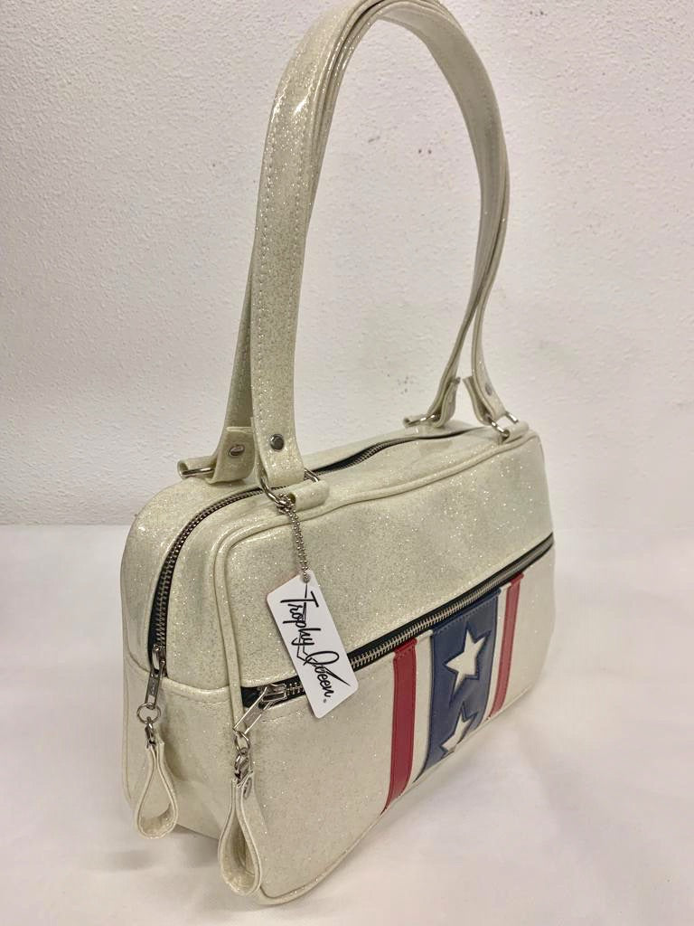 Evel Knievel Tote Bag lined with plush leopard is handcrafted in California with nickel hardware and 25” straps plus it comes with replacement straps. Inside open divided pocket and inside zipper pocket with serial number hidden inside. Nickel feet, vinyl zipper pull, and signature Trophy Queen Label included. The perfect size bag for any trip!