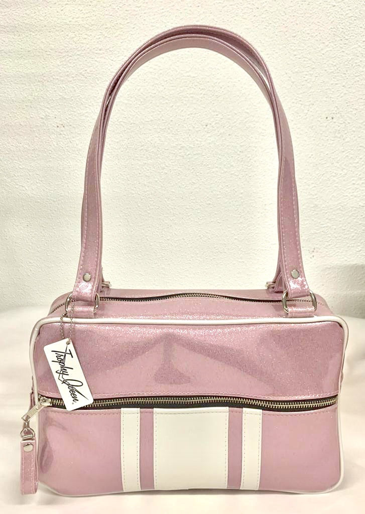 GTO Tote Bag in Blush Pink Glitter and Pearl White Vinyl with Plush Leopard Lining has matching vinyl zipper pull, nickel feet, inside zipper pocket with serial number and open divided pocket with signature Trophy Queen label. The straps are approximately 25” and come with an extra set of replacement straps. Locally made and ships from California.