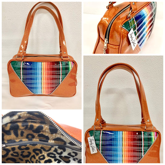 Comet Tote in Mexican blanket with clear overlay and tangerine glitter vinyl with plush leopard lining handcrafted in California with nickel hardware, an extra set of straps, vinyl zipper pull, inside open divided pocket, zipper pocket with serial number inside and signature Trophy Queen label.
